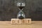 Debt, financial obligation driving economic bubble burst countdown concept, sandglass or hourglass on wooden cube block with