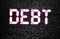 Debt pink neon word on black brick wall. Financial agreement credit obligations concept