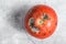 Decayed rotten tomato. Gray background. Top view. Space for text