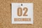 december 02. 02th day of the month, calendar date.White calendar sheet attached to brown cork board.Winter month, day of