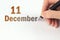 December 11st . Day 11 of month, Calendar date. The hand holds a black pen and writes the calendar date. Winter month, day of the