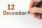 December 12nd. Day 12 of month, Calendar date. The hand holds a black pen and writes the calendar date. Winter month, day of the