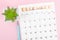 December 2022 calendar and plant pot with pen on pink background