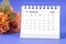 The December 2023 Monthly desk calendar for 2023 year with flower on purple background