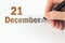 December 21st . Day 21 of month, Calendar date. The hand holds a black pen and writes the calendar date. Winter month, day of the