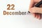 December 22nd. Day 22 of month, Calendar date. The hand holds a black pen and writes the calendar date. Winter month, day of the