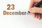 December 23rd. Day 23 of month, Calendar date. The hand holds a black pen and writes the calendar date. Winter month, day of the