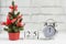 December 25 on a wooden calendar next to the clock and Christmas tree, the concept of Christmas