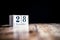 December 28th, 28 December, Twenty Eighth of December - White block calendar on vintage table - Date on dark background