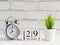 December, alarm clock and calendar on the table December 29 on a wooden calendar next to the clock