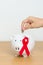 December World Aids Day, acquired immune deficiency syndrome, Red Ribbon with Piggy Bank for support illness life. Health,