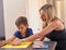 Deciding on age appropriate chores. a little boy and his mother preparing a chore list at home.