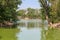 Deciduous forest is reflected in a water smooth surface of the lake.