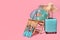 Deck chair, suitcase and beach accessories on pink background, space for text