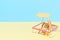 Deck chair with umbrella, surfboard and ball on the beach. An isolated vacation spot at a resort.