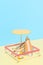 Deck chair with umbrella, surfboard and ball on the beach. An isolated vacation spot at a resort.