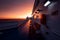 Deck of ferry sailing across the sea during last moments of a beautiful sunset with arriving land in the background. Concept of