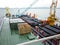 The deck lay barge. Pipes and Lifting cranes on the ship. Equipment for laying a pipeline on the seabed