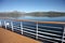 Deck & railing of a ship as it cruises fjords; the Andfjorden & Vestfjorden, between Bodo & Hammerfest, Norway.