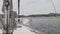 Deck of a white yacht with a blue rope in ocean.