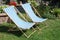 Deckchair chaise chair in cafe garden park grass, with blue red stripes relax