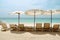 Deckchairs, white sand and sea sky.