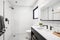 decluttered bathroom with white tiles, sleek fixtures, and minimalist decor