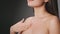 Decollete skin care. Semi profile portrait of young unrecognizable lady applying moisturizing cream on her chest