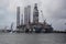 Decommissioned oil rig with transport ships in port at Galveston Harbour