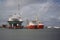 Decommissioned oil rig with transport ships in port at Galveston Harbour