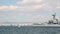 Decommissioned old warship on the coast of Thessaloniki city, Greece, clouds over blue sky and residential buildings