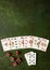 Decomposed deck of playing cards and red dice on green textured