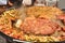 Decomposed street food on a large metal tray, close up.Fried chicken,sausages, fried zucchini,meat,fish,Uzbek pilaf