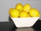 decomposing lemons stacked in a bowl