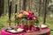 Decor. Details. Composition. Wedding decorations. On the wooden table in the woods there is a flower arrangement with