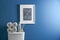 Decor elements, necessities and toilet bowl near blue wall. Bathroom