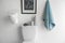 Decor elements, necessities and toilet bowl near white wall. Bathroom