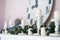 Decor fireplace candles, clock face and fir branches. Close up. Selective focus