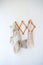 Decor items hang on a white wall on a wooden hanger. Macrame , towels. Rustic style.