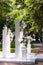 decor of wedding celebration in nature, white columns with vases with flowers, side view, lush white flowers in vases stand