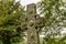 A decorated Celtic cross monument in nature.