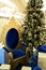 A decorated Christmas tree with a golden armchair with blue velvet next to it. A blue gold armchair and many gifts decorated to
