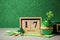 Decorated cupcake, wooden calendar, hat and coins on grey table. St. Patrick`s Day celebration