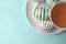 Decorated Easter eggs in a bowl, closeup on pastel background