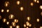 Decorated electric garland for lighting with bulbs warm white and yellow light on a dark background. Blurred background. Bulbs in