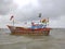 Decorated fishing boat floating near the sea shore of Arabian sea during high tide rainy weather. Indian fishermen