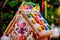 Decorated gingerbread house with candy on christmas tree background