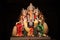 Decorated idol of Lord Ganesha with black background.
