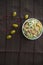 Decorated with lettuce, side view, selective focus . Orange pepper in a green bowl . Water in a glass. Brown tablecloth. Salad