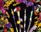 Decorated magic wands in circle of flowers, top view